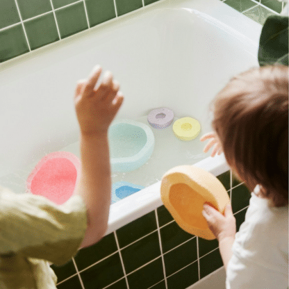 kinderen die met stapelstein spelen in een groen bad